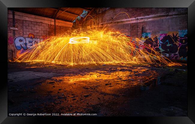 Showers of hot glowing sparks from spinning steel  Framed Print by George Robertson