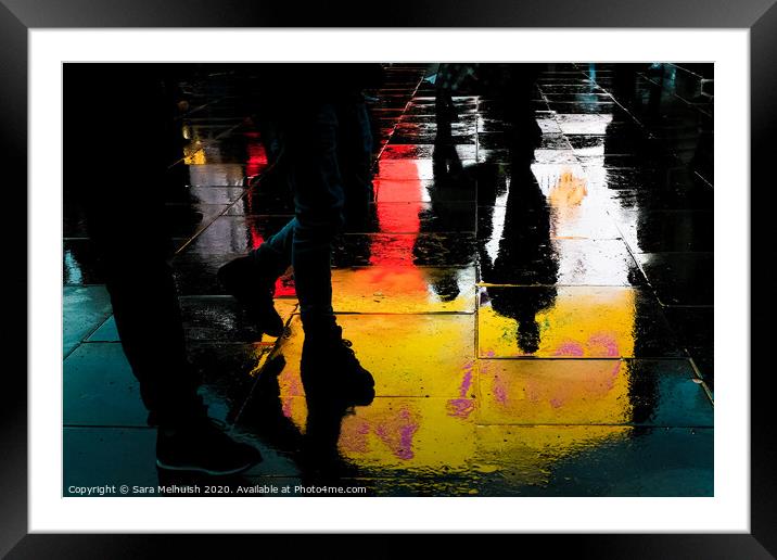 Feet and reflections in wet pavement Framed Mounted Print by Sara Melhuish