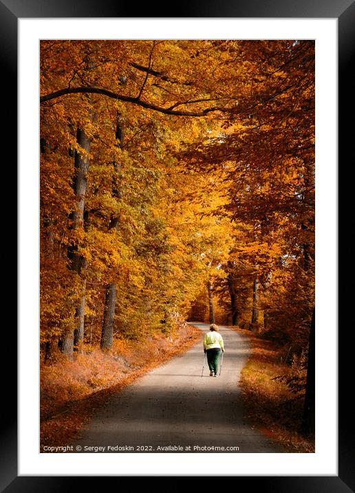 Woman on the road in the autumn forest. Framed Mounted Print by Sergey Fedoskin