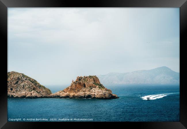 The yacht sails near the rocks Framed Print by Andrei Bortnikau