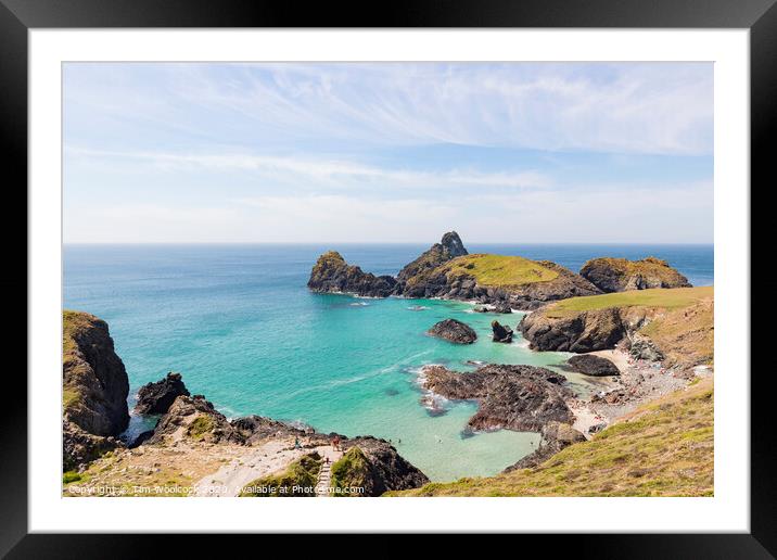 A rocky island in the middle of a body of water with Kynance Cove in the background Framed Mounted Print by Tim Woolcock