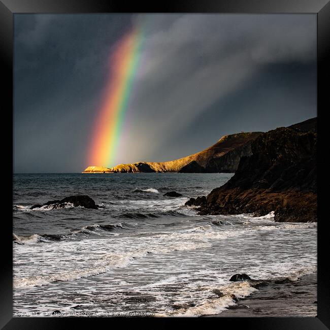 Rainbow light on headland at Cardigan Bay Framed Print by Joy Newbould