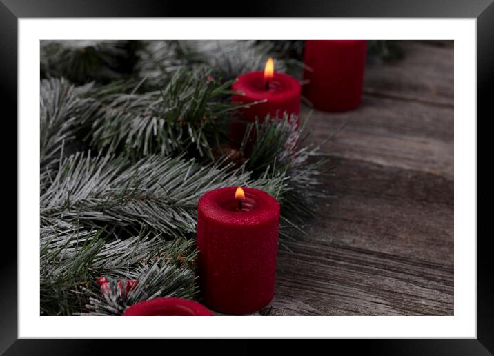 Red glowing candles with fir and wood dark background  Framed Mounted Print by Thomas Baker