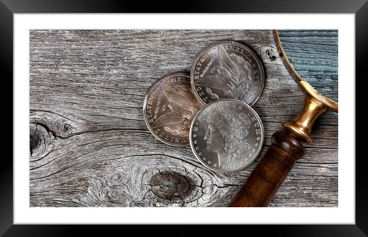 Collection of US Morgan silver dollars with magnifying glass  Framed Mounted Print by Thomas Baker