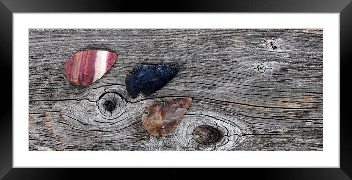 Three Native American arrowheads on rustic wood  Framed Mounted Print by Thomas Baker