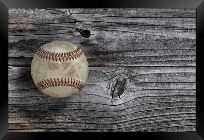 Single used baseball on vintage wooden background. Framed Print by Thomas Baker