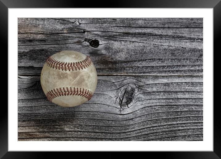 Single used baseball on vintage wooden background. Framed Mounted Print by Thomas Baker