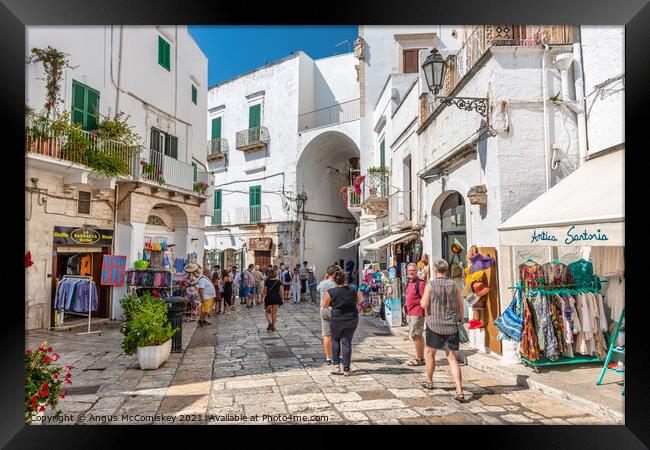 Tourists on Via Cattedrale in Ostuni, Italy Framed Print by Angus McComiskey