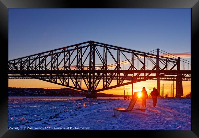 People going for an evening walk at sunset by the frozen St Lawrence River, Quebec, Canada Framed Print by Colin Woods