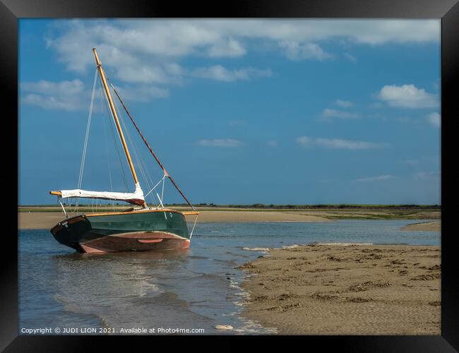 Green boat in shallow water Framed Print by JUDI LION