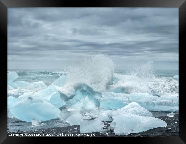 Waves breaking over blocks of ice Framed Print by JUDI LION