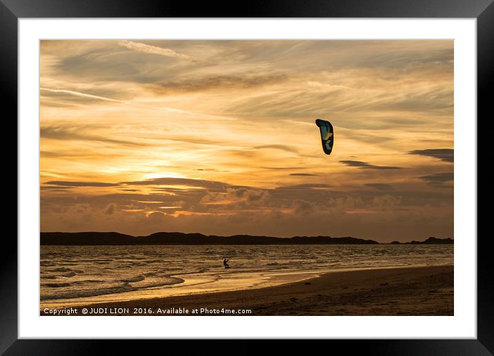 Kite surfer riding along the tideline at sunset Framed Mounted Print by JUDI LION