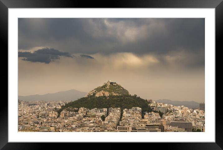 Lycabettus hill rises above Athens on stormy day Framed Mounted Print by Steve Heap