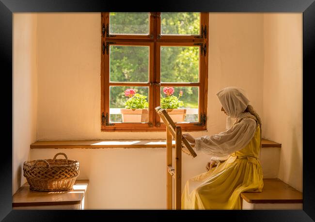 Woman working on embroidery in window alcove Framed Print by Steve Heap
