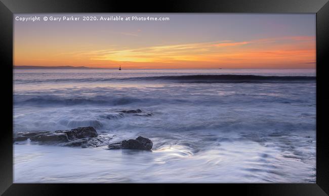 Waves rolling over rocks on the shoreline Framed Print by Gary Parker