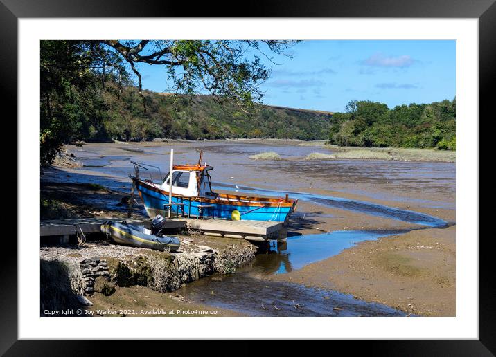 A small fishing boat moored while the tide is out Framed Mounted Print by Joy Walker