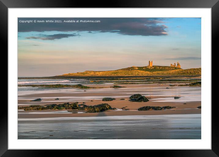 Sunsetting over Dunstanburgh castle on Embleton beach Framed Mounted Print by Kevin White