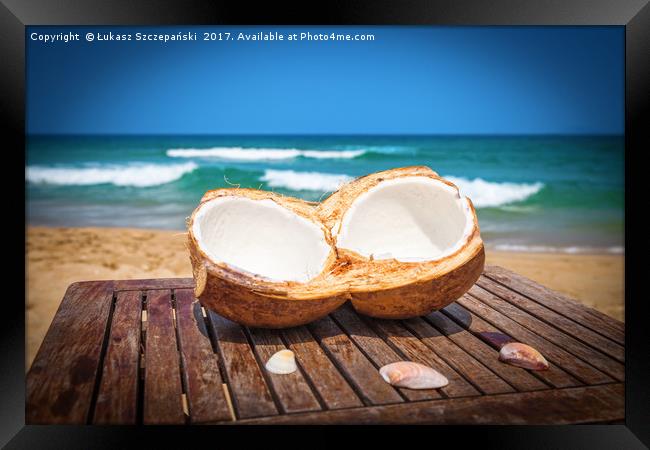 Coconut on the table against beautiful beach Framed Print by Łukasz Szczepański