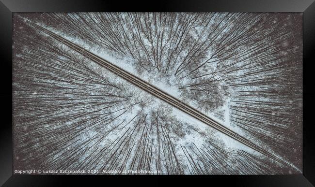 Road through winter forest Framed Print by Łukasz Szczepański