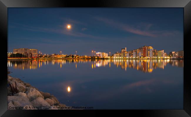 The moon and cityscape lights, reflect off harbour Framed Print by Alan Hill