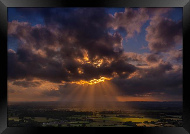 Crepuscular rays of sunlight shine onto fields in Dorset Framed Print by Alan Hill