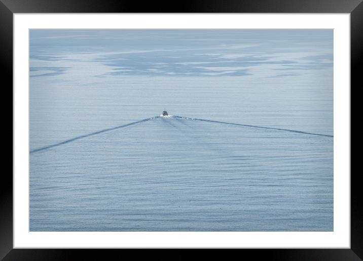 A small boat and its wake on a calm sea. Framed Mounted Print by Dave Collins