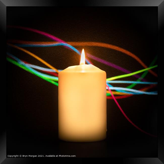 Burning candle with streaks of coloured light Framed Print by Bryn Morgan