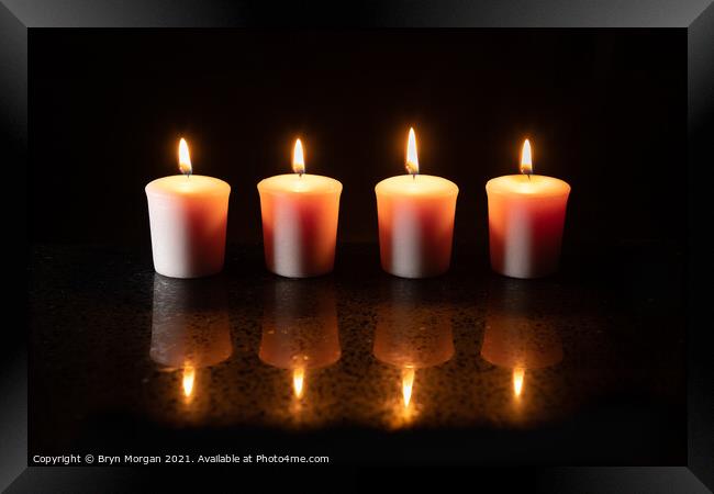 Four burning candles with reflections Framed Print by Bryn Morgan