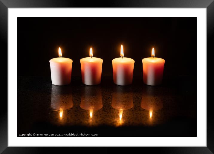 Four burning candles with reflections Framed Mounted Print by Bryn Morgan