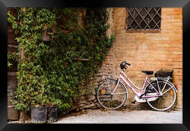 Bicycle leaning against a wall  Framed Print by Marco Bicci