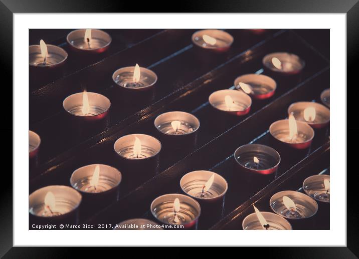 Rows of brightly burning votive candles Framed Mounted Print by Marco Bicci