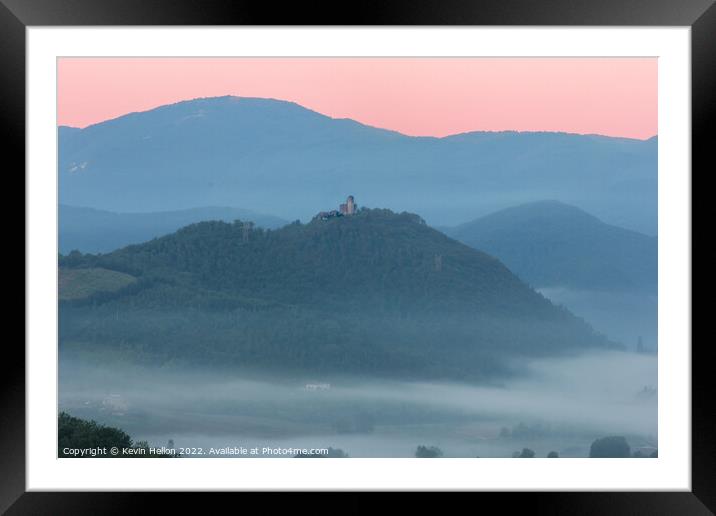 Hilltop castle surrounded by early morning mist Framed Mounted Print by Kevin Hellon