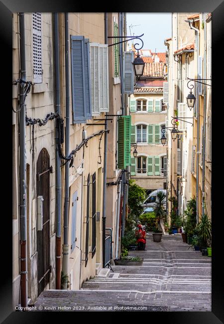 Steep, narrow street in old Marseille, France Framed Print by Kevin Hellon