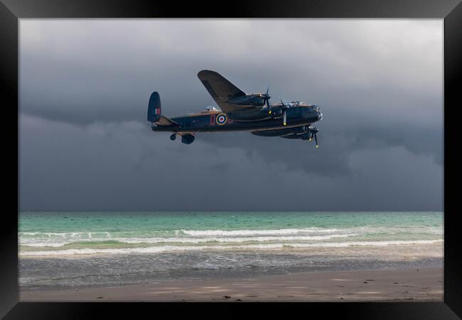 Lancaster bomber over the sea and under a dark, cloudy sky Framed Print by Kevin Hellon