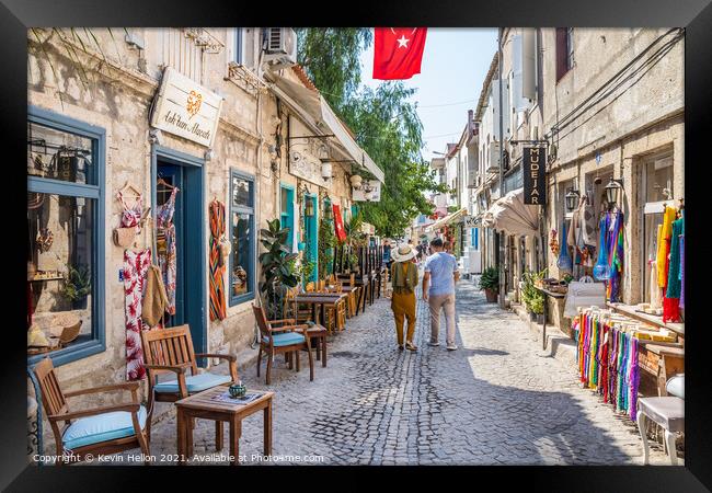 Couple walking down a narrow street Framed Print by Kevin Hellon