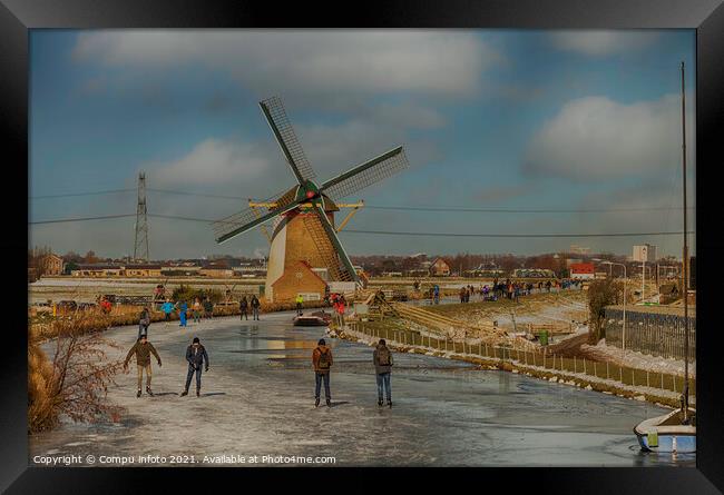 People skating om ice with windmill as background Framed Print by Chris Willemsen