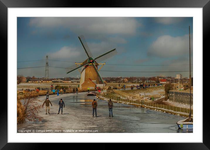People skating om ice with windmill as background Framed Mounted Print by Chris Willemsen