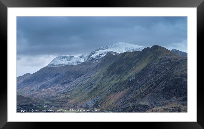 Beautiful landscape image of Dinorwig Slate Mine and snowcapped Snowdon mountain in background during Winter in Snowdonia with Llyn Peris in foreground Framed Mounted Print by Matthew Gibson