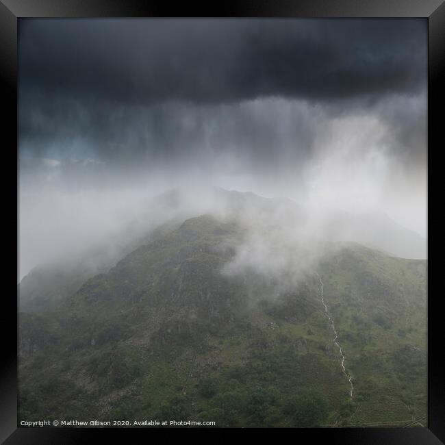Dramatic landscape image of storm clouds hanging over Snowdonia mountain range with heavy rainfall in Autumn with misty weather Framed Print by Matthew Gibson