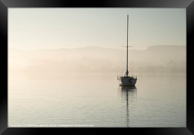 Stunning unplugged fine art landscape image of sailing yacht sitting still in calm lake water in Lake District during peaceful misty Autumn Fall sunrise Framed Print by Matthew Gibson