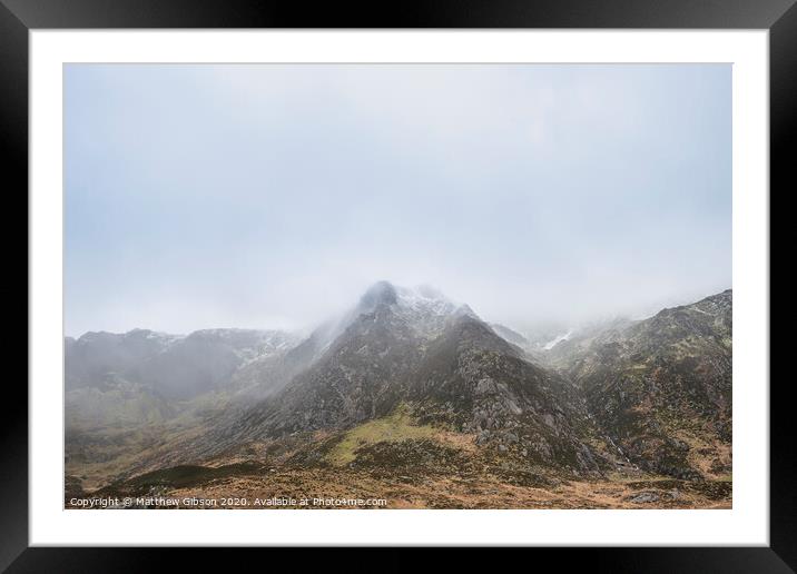 Stunning moody dramatic Winter landscape image of snowcapped Y Garn mountain in Snowdonia Framed Mounted Print by Matthew Gibson