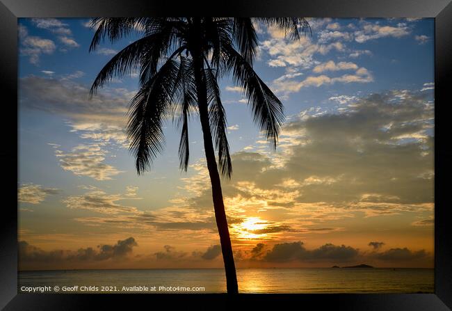 Tropical sunrise seascape with a palm tree silhouette in a blue  Framed Print by Geoff Childs