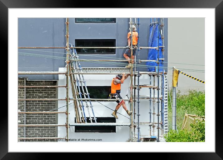 Construction workers dismantling scaffolding on new construction Framed Mounted Print by Geoff Childs