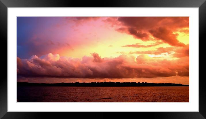 Cloud bank highlighted sunset seascape.  Framed Mounted Print by Geoff Childs