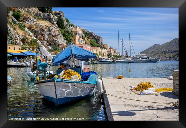 Fisherman repairing nets at Symi harbour. Framed Print by Chris North