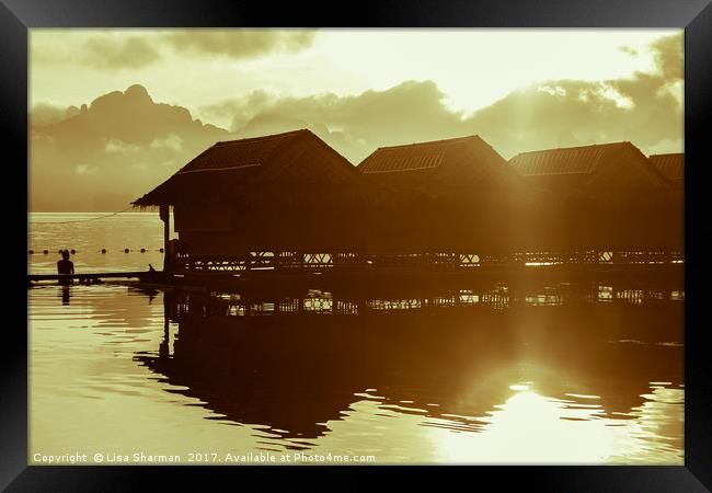 Sun rising over cute little wooden huts perched on Framed Print by  