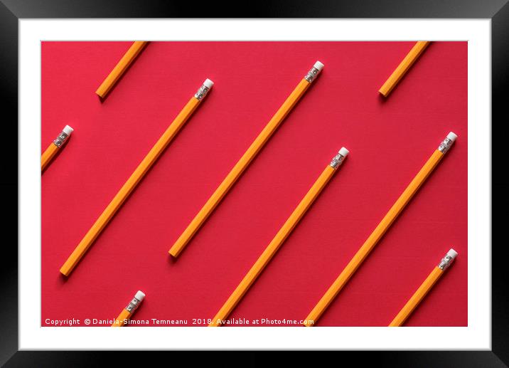 Yellow wooden pencil on red background Framed Mounted Print by Daniela Simona Temneanu