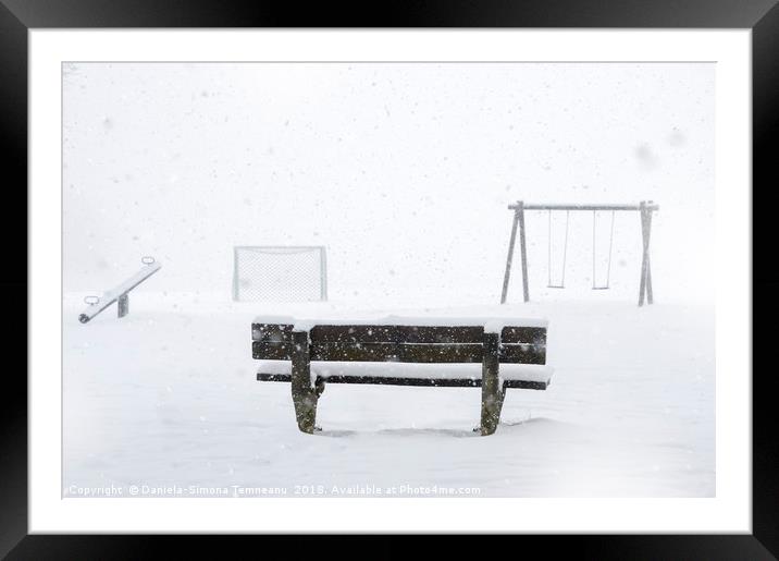 Playground and bench covered by snow Framed Mounted Print by Daniela Simona Temneanu
