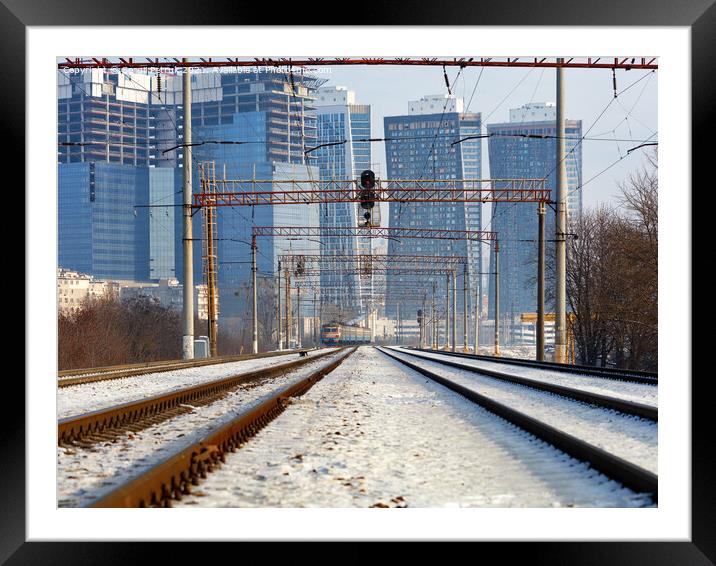 Winter cityscape, electric train moving on rails, central perspective. Framed Mounted Print by Sergii Petruk