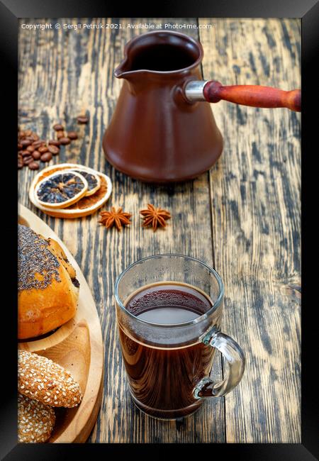 Freshly brewed espresso coffee in a transparent glass cup against the background of an old table, dried citrus fruits and brown turks in blur. Framed Print by Sergii Petruk